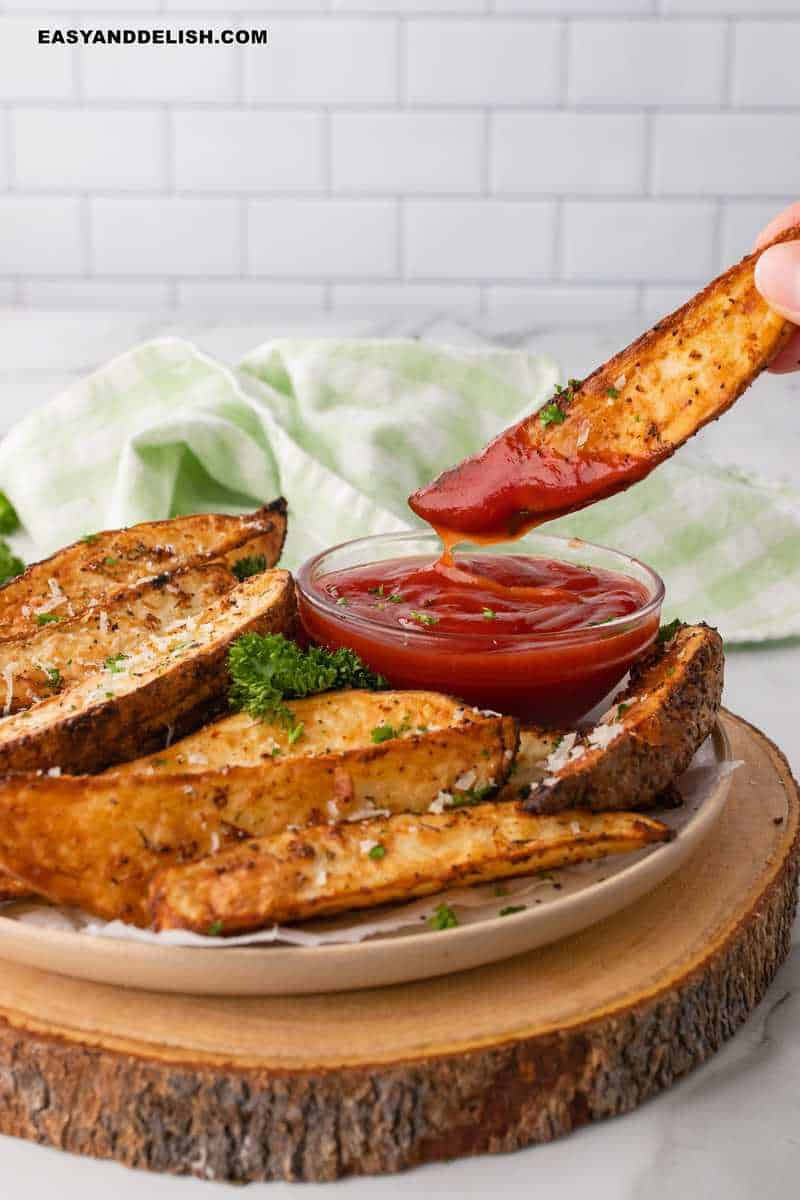 uma batata na airfryer sendo mergulhada em ketchup