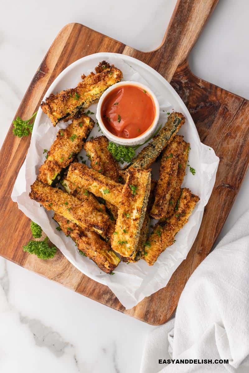 a platter with fried summer squash adn sauce plys parsley