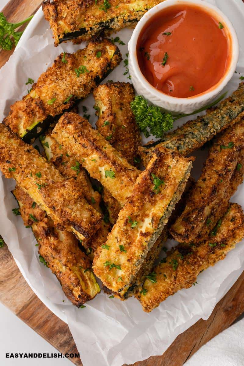 air fryer zucchini fries in a platter with sauce on the side