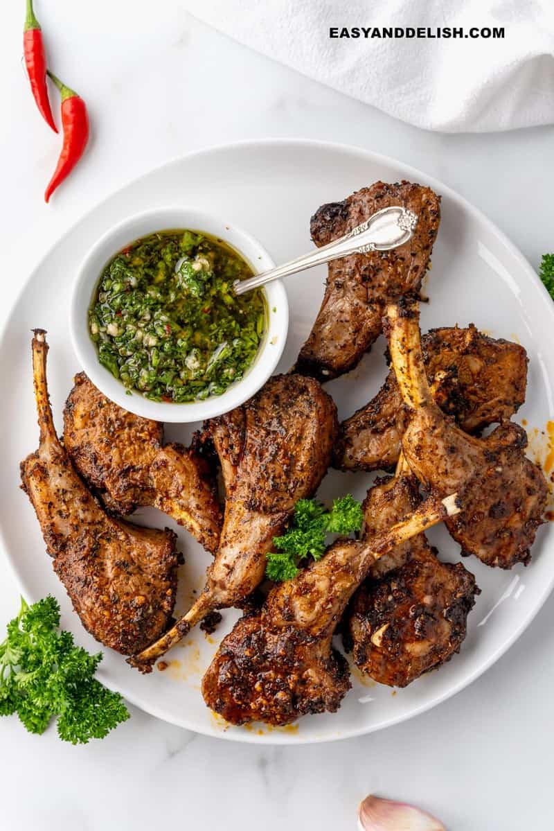 air fryer lamb chops in a palted with a bowl of chimichurri sauce on the side for high protein dinners