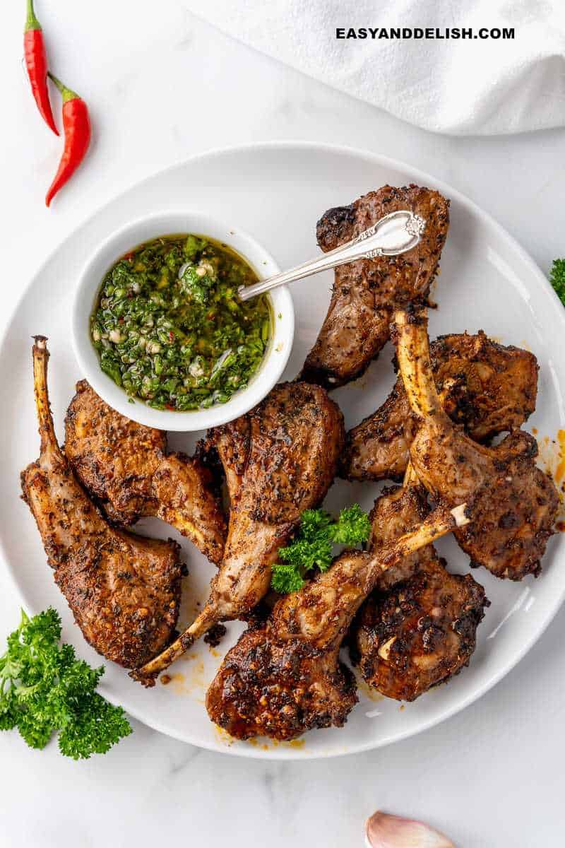 air fryer lamb chops in a palted with a bowl of chimichurri sauce on the side for high protein dinners