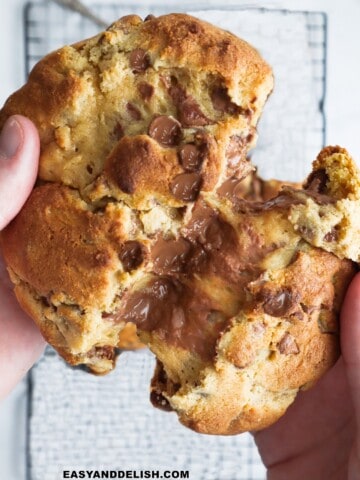 One cookie of a small batch chocolate chip cookies split in half showing goeey center.