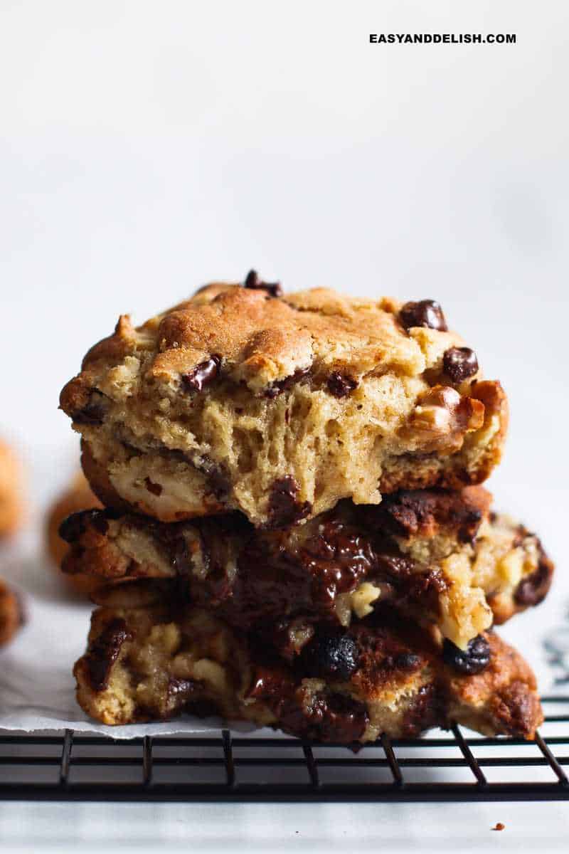 a pile of chocolate chip walnut cookies with gooey centers