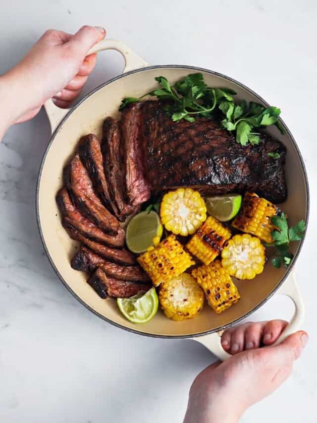grilled flank steak in a pan with veggies for high protein dinners for busy people on a high protein diet