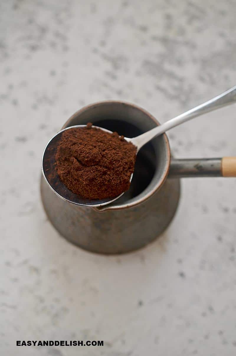 a spoon of espresso coffee over a pot