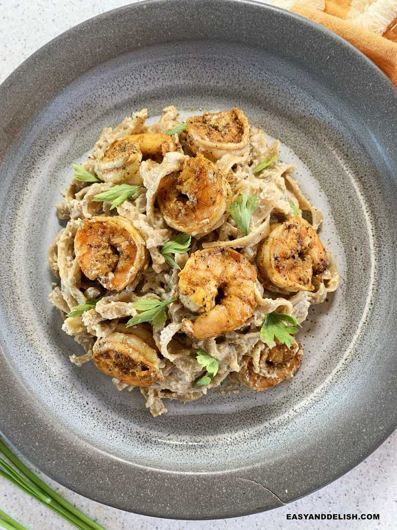 um prato com macarrão ao molho branco com camarão