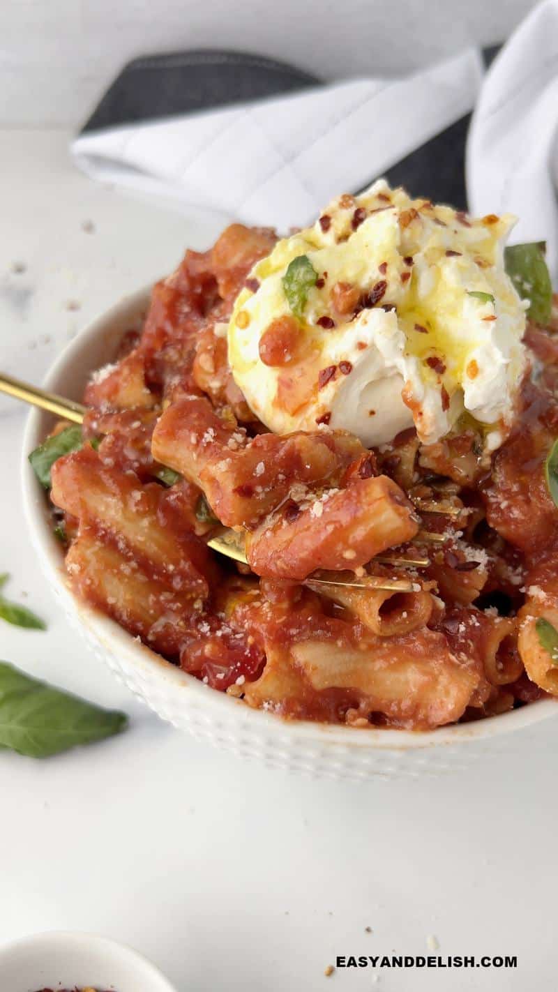  a napkin and guarnishes around a bowl of Italian comfort food 