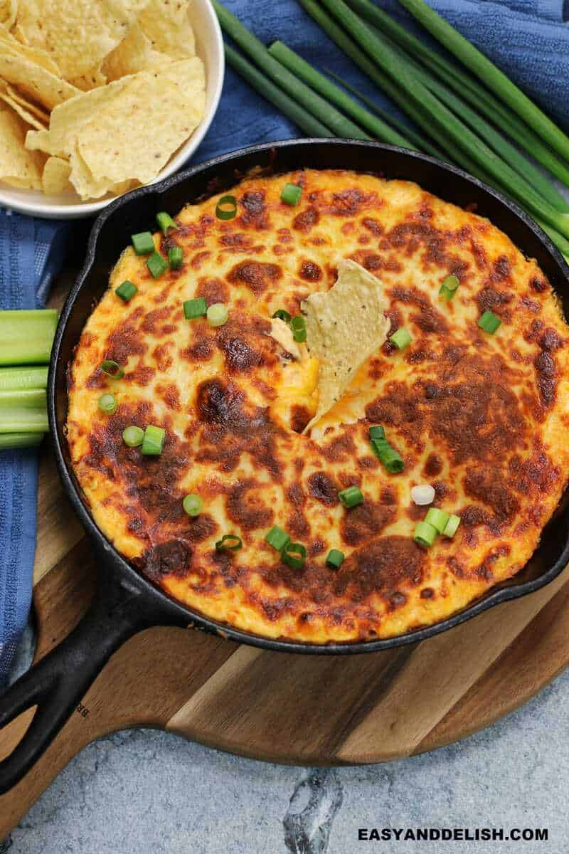 a hot appetizer in a skillet with garnishes on the side