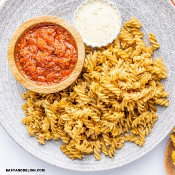 um prato com macarrão frito e molhos ao lado