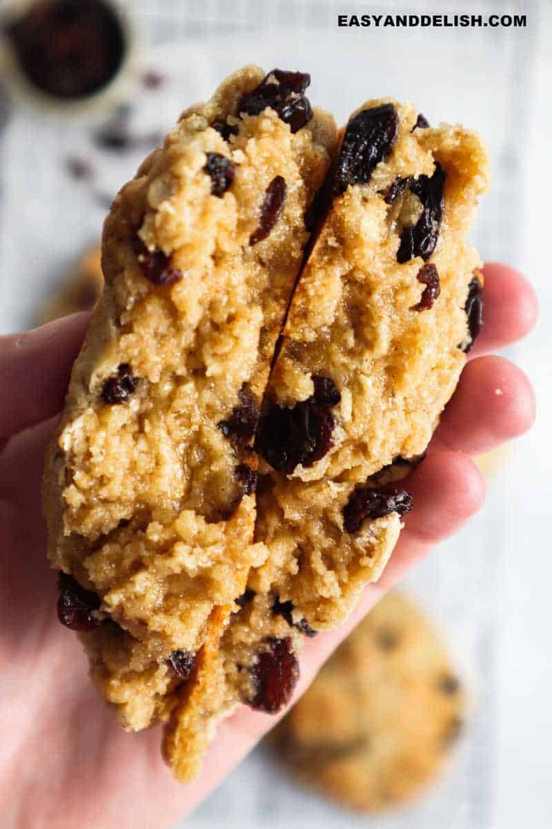 halved chewy oatmeal raisin cookie in a hand