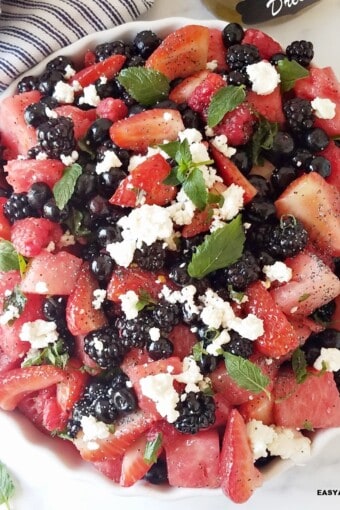 close up of a bowl of berry salad tossed with lemon poppy seed dressing