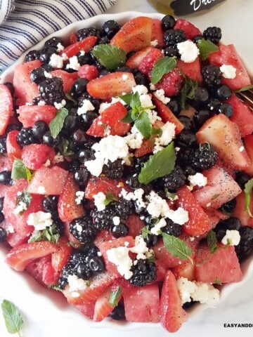 close up of a bowl of berry salad tossed with lemon poppy seed dressing