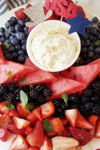 close up of keto cream cheese fruit dip with fruits around decorated for the fourth of july