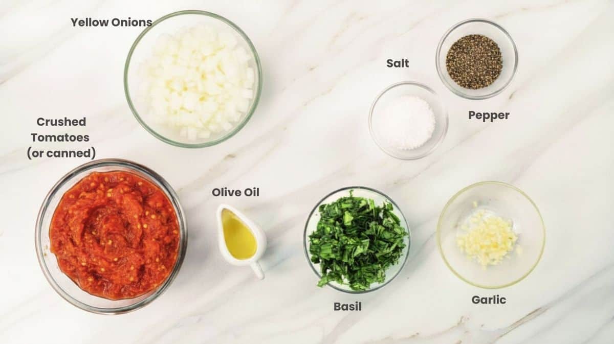 Ingredients for pomodoro sauce including tomatoes, garlic, olive oil, and basil.