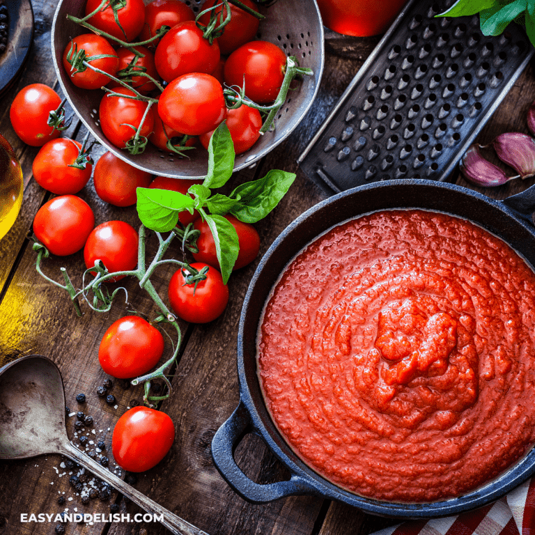 bowl of pomodoro sauce with tomatoes and basil around
