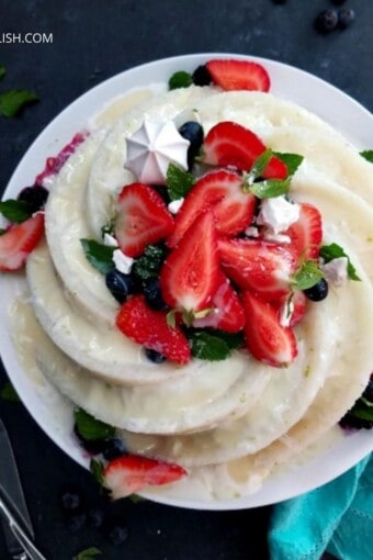 bolo de tapioca granulada gelado decorado com coco, leite condensado e frutas