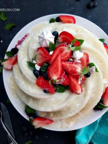 bolo de tapioca granulada gelado decorado com coco, leite condensado e frutas