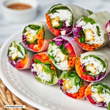 close up of a pile of summer, fresh Vietnamese spring rolls with peanut sauce