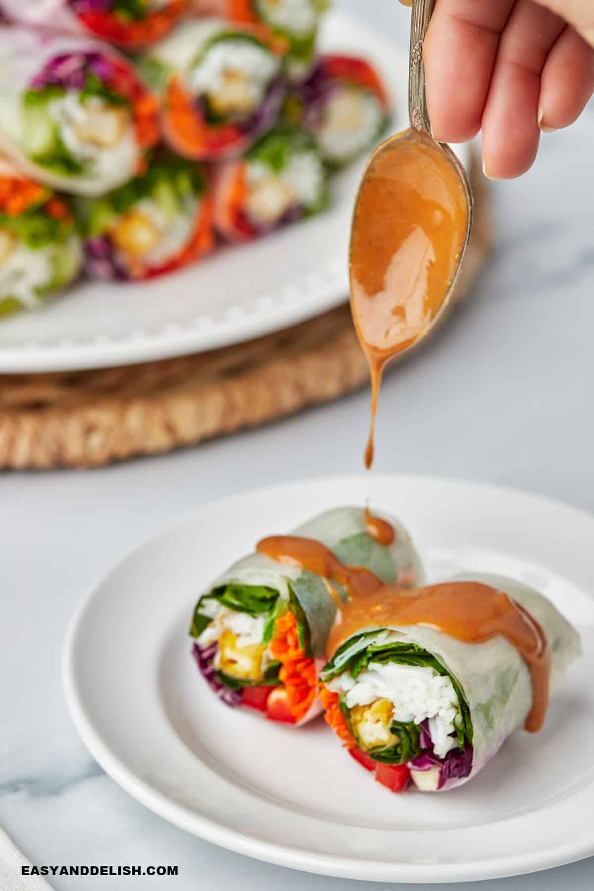 vegan peanut sauce spooned over Vietnamese spring rolls