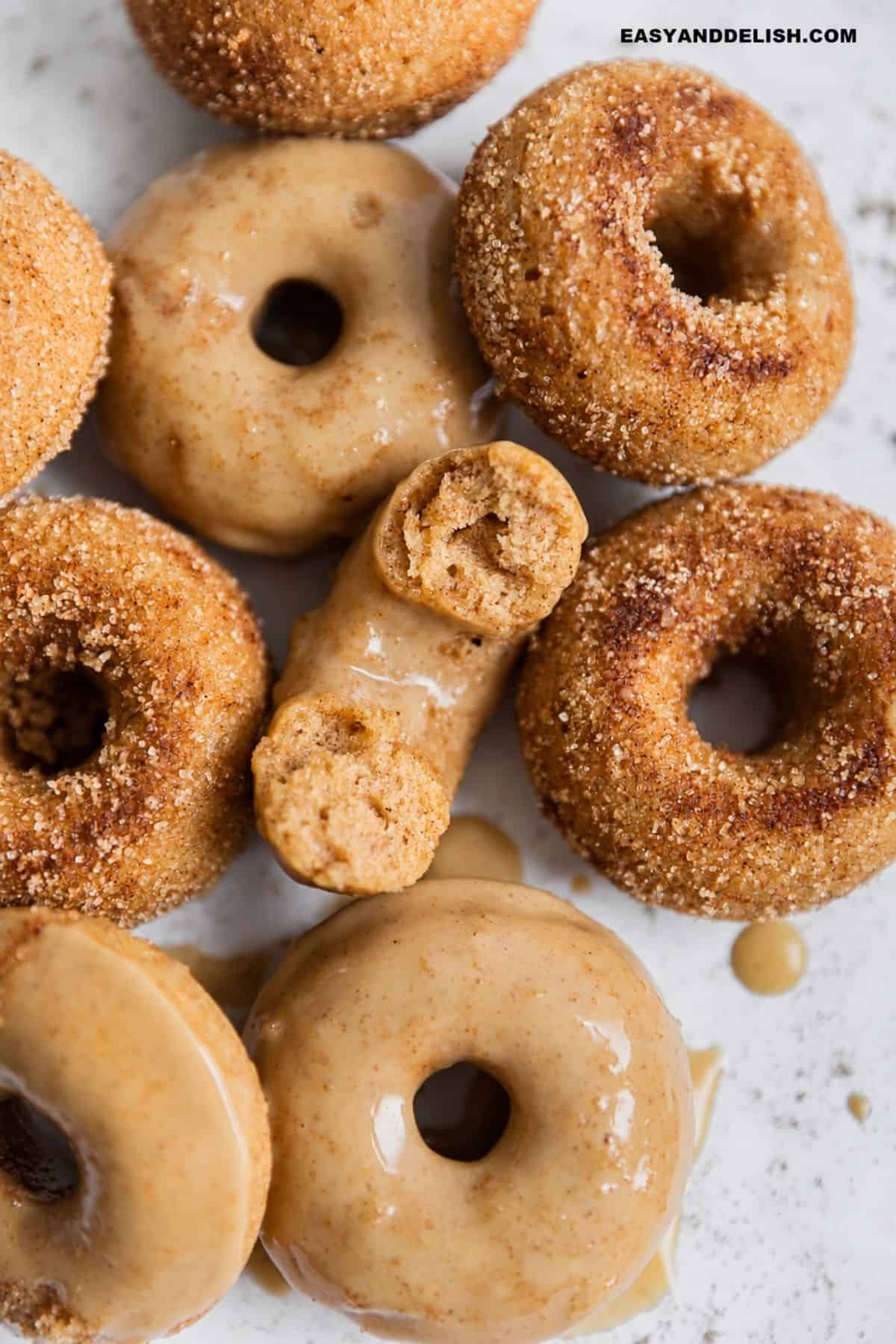 Baked donuts with maple glaze and cinnamon sugar, including cut donuts showing the cake-like center.