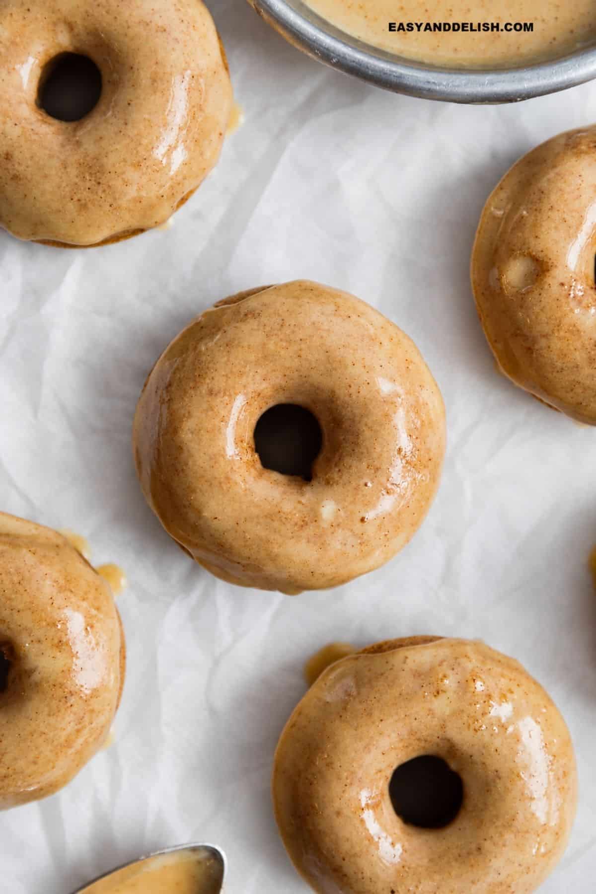 Apple cider donuts covered with a glossy maple cinnamon glaze.