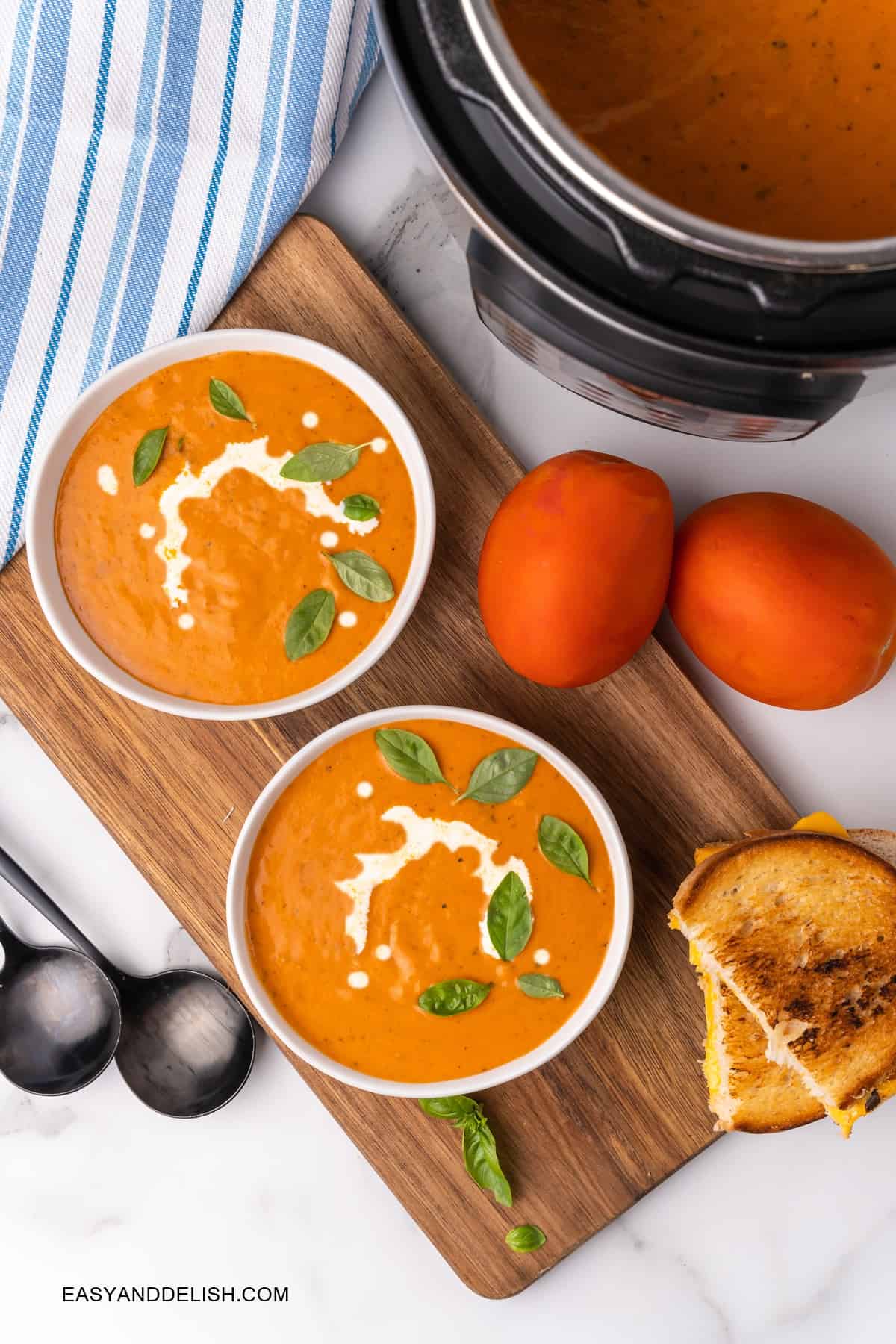 Keto tomato soup in bowls with tomatoes on the side and an Instant Pot on the background
