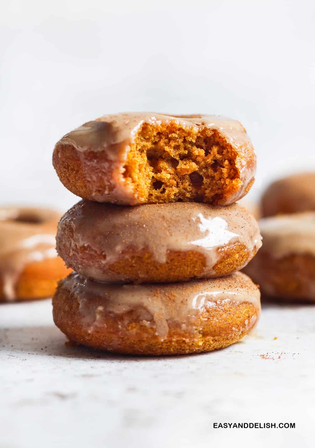A PILE OF BAKED PUMPKIN DONUTS ON A TABLE
