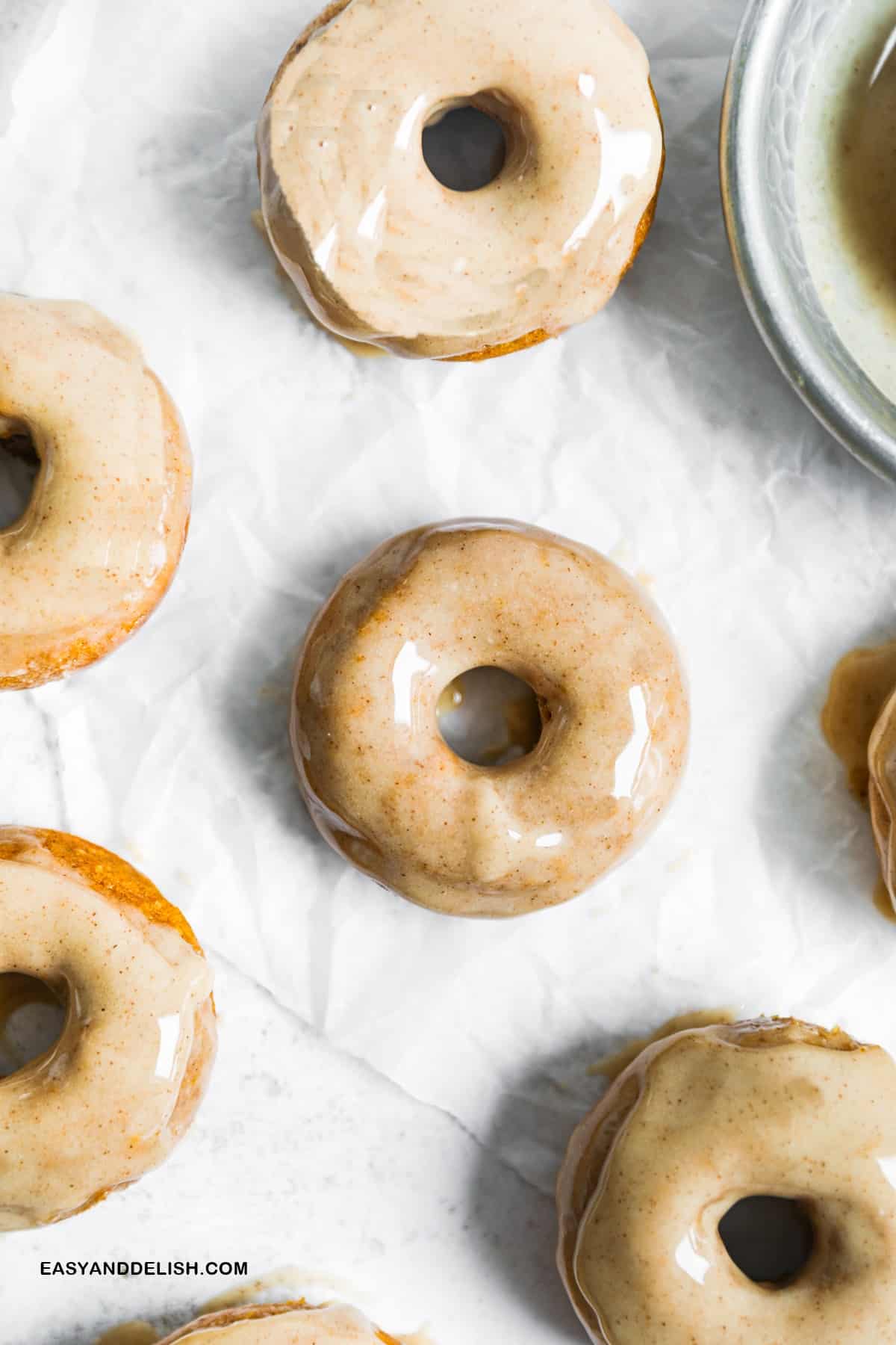 whole glazed pumpkin donuts on a table