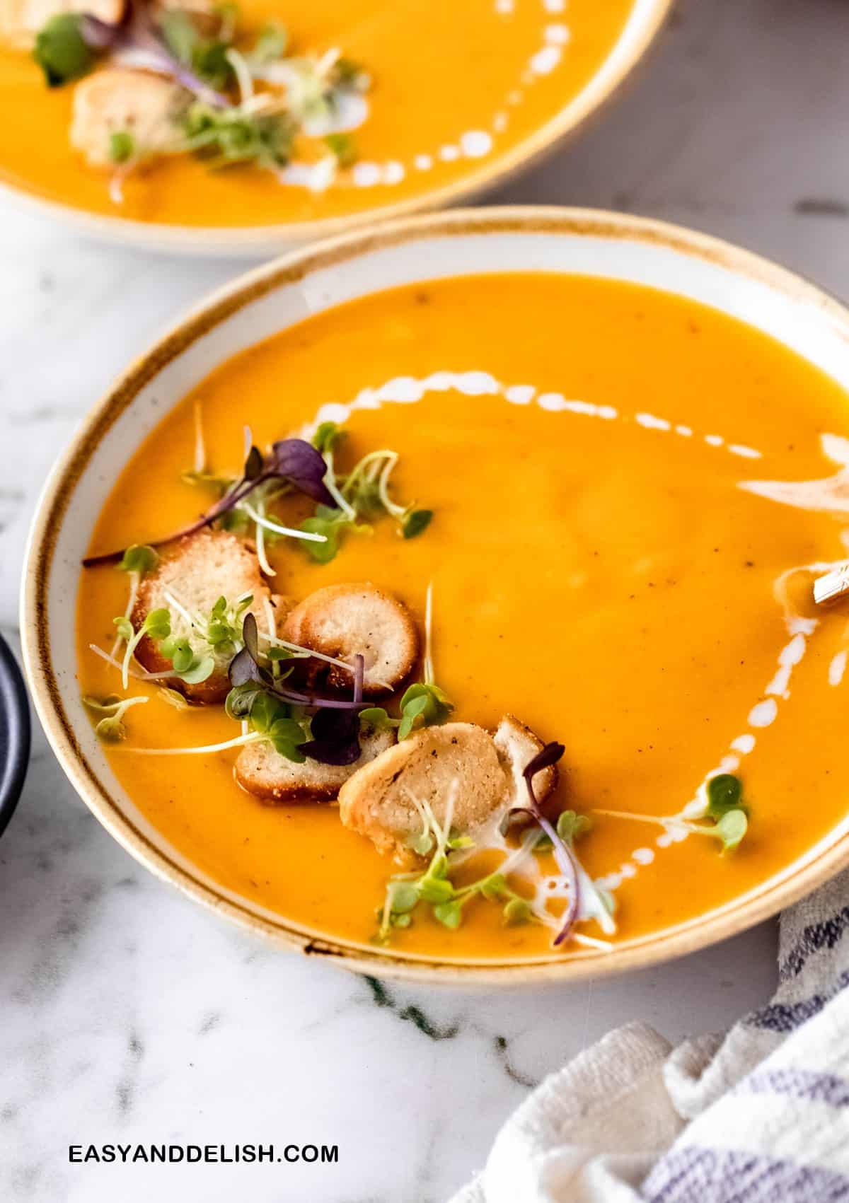 close up of part of a bowl of vegan sweet potato soup on a table