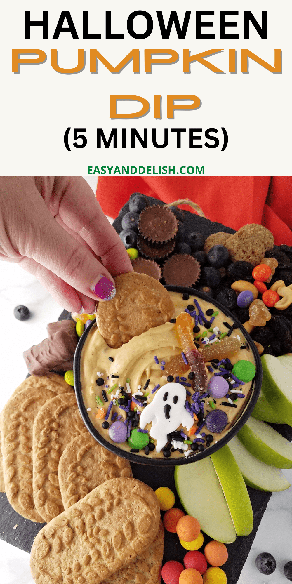 close up of a a bowl of pumpkin dip with cookies and other dippers decorated for Halloween