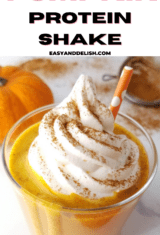 a close up of a galss of pumpkin pie protein shake on a table.