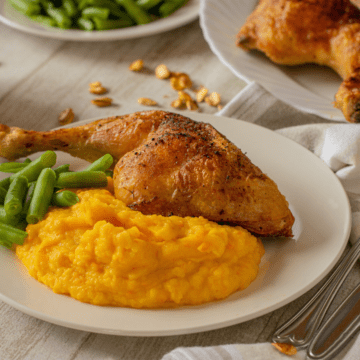 purê de abóbora em um prato com frango e legumes