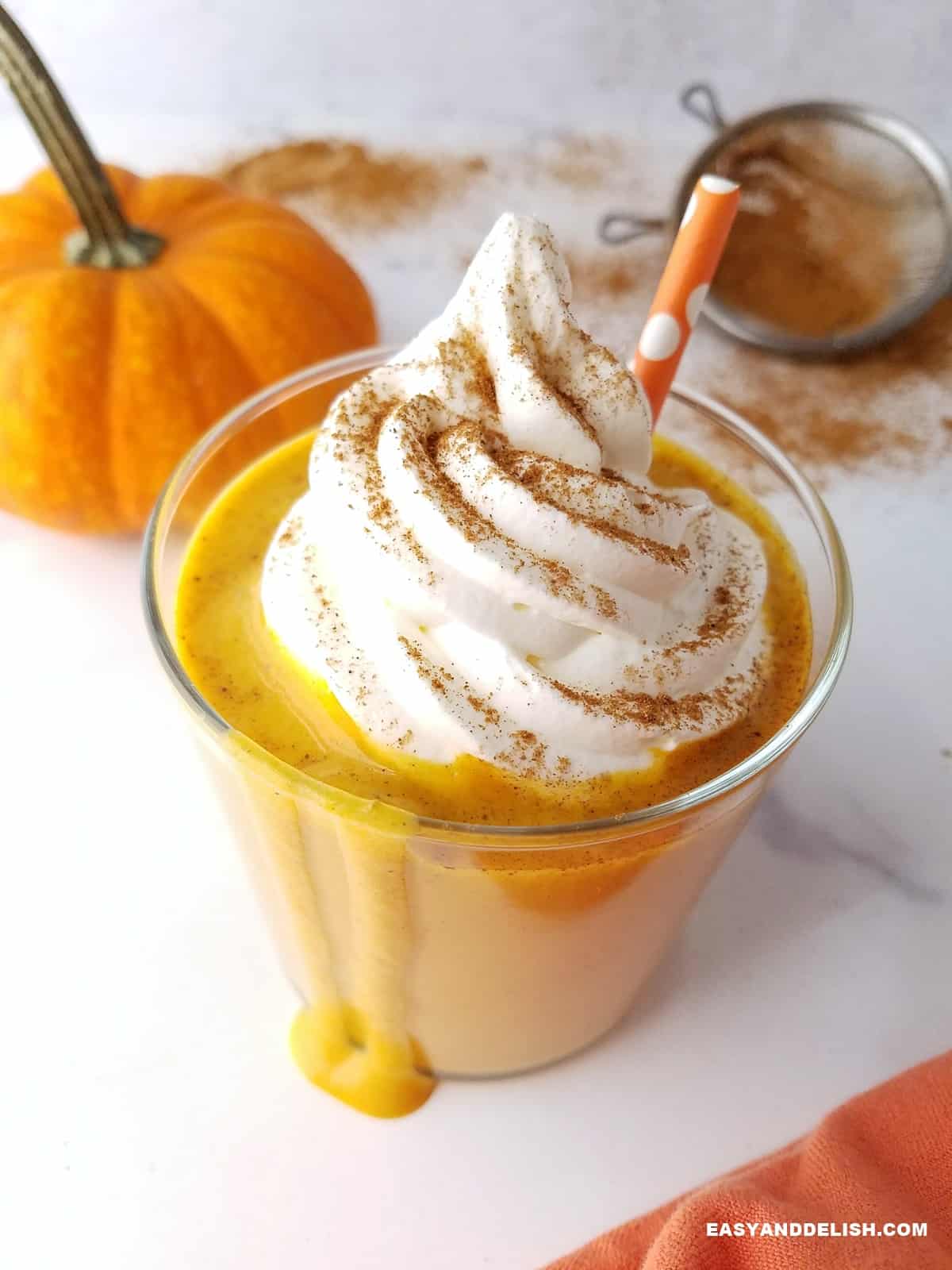 a glass of pumpkin pie protein shake dripping from top to bottom.