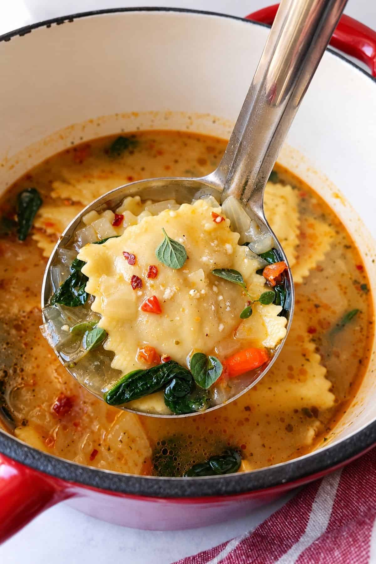 Cheese ravioli with spinach and herbs lifted from the broth with a ladle.