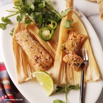 keto tamales for Christmas on a platter with jalapenos, cilatro, and lime wedges on the sside.