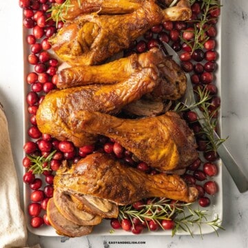 smoked turkey legs with cranberries and rosemary sprigs.