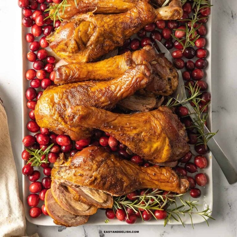 smoked turkey legs with cranberries and rosemary sprigs.