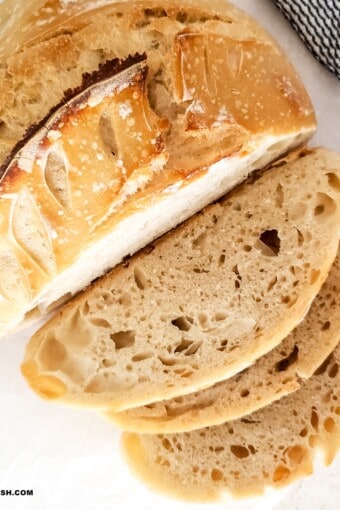 partially sliced easy sourdough bread on a table.