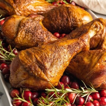 Smoked turkey legs in a platter garnished with Thanksgiving.