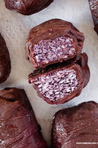 several whole keto protein bars surrounding a cut bar showing the filling.