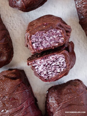 several whole keto protein bars surrounding a cut bar showing the filling.