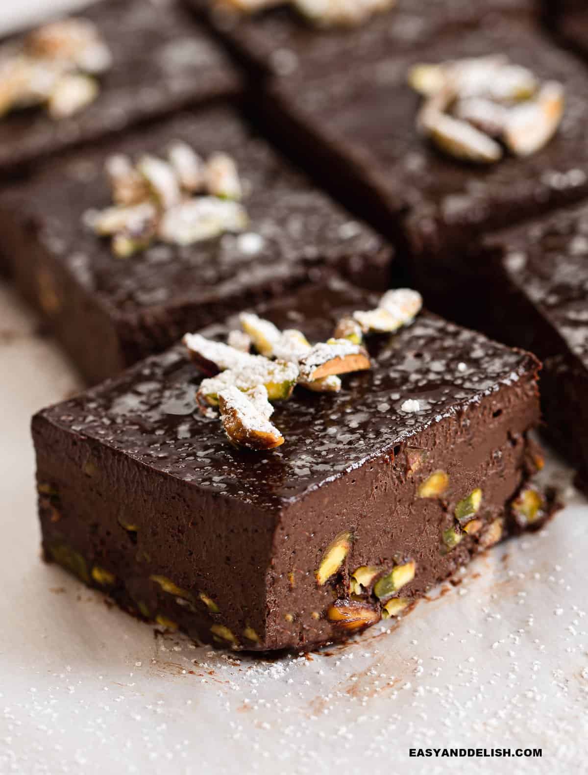 one of several slcies of no bake sugar-free brownies topped with pistachios.
