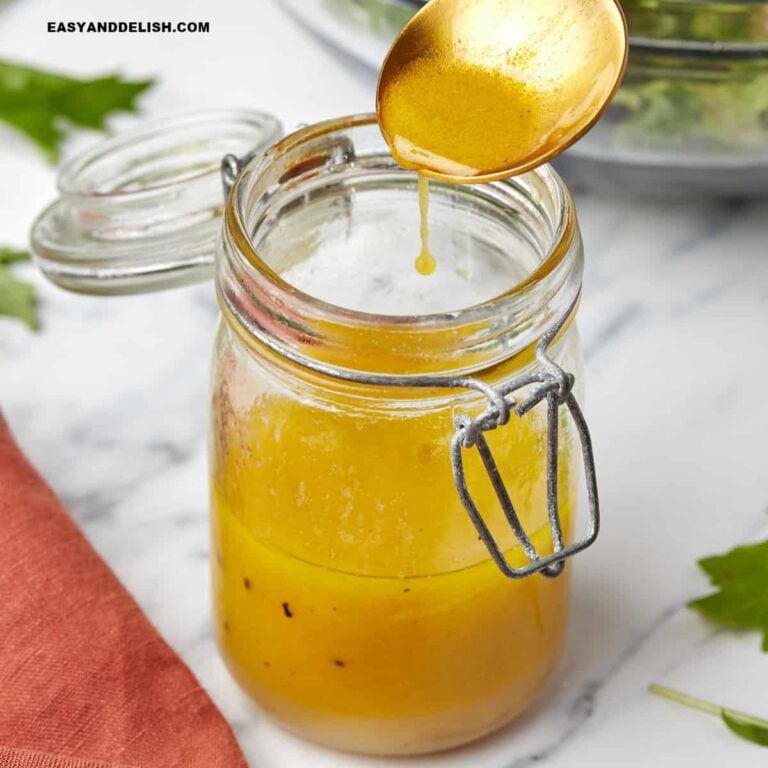 A spoon over a jar with apple cider vinaigrette .