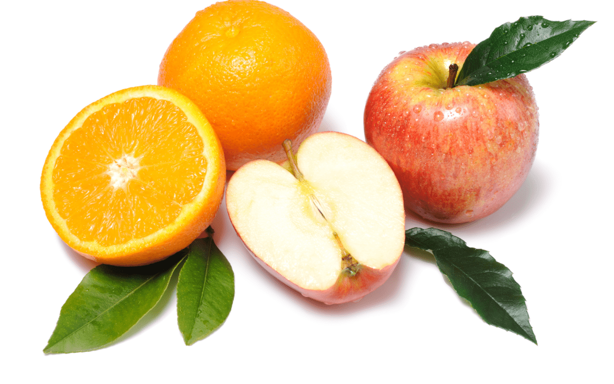 a sliced orange and apple on a table.