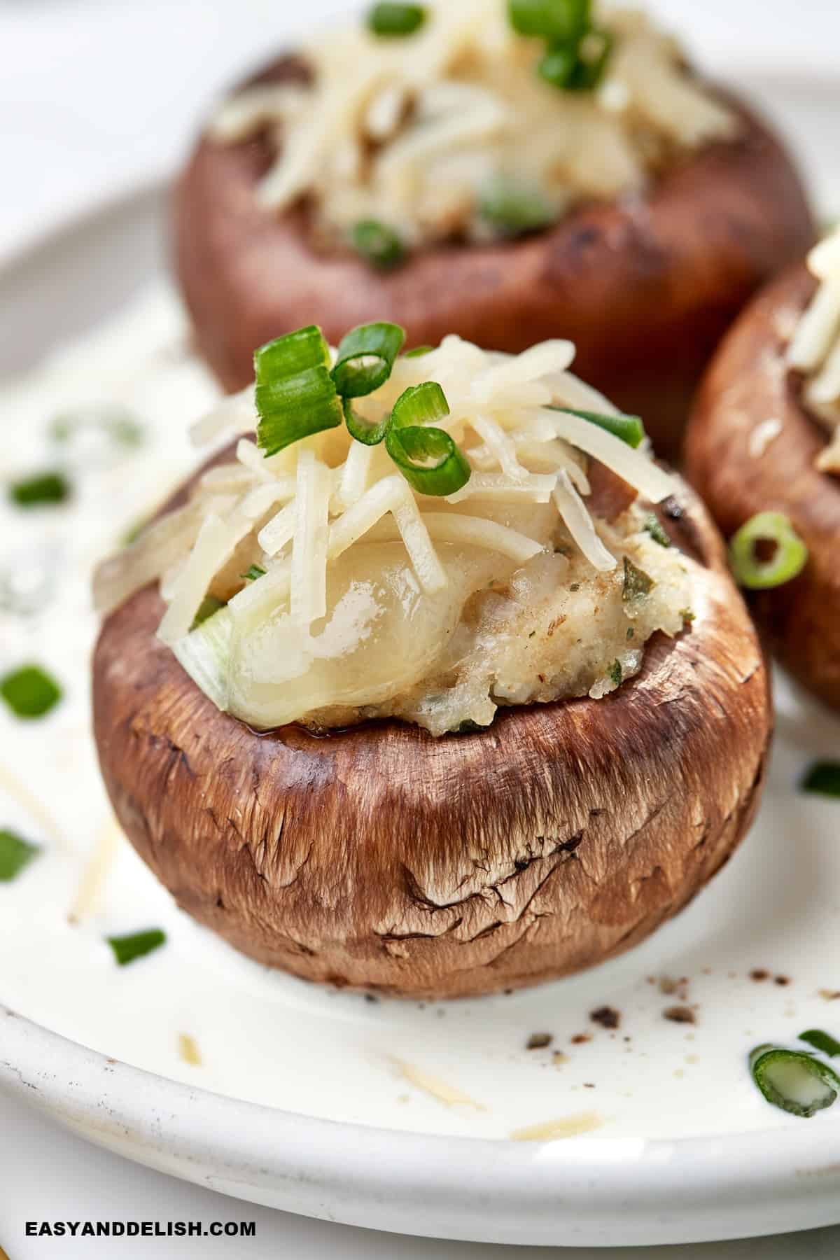 a plate with three stuffed mushrooms.