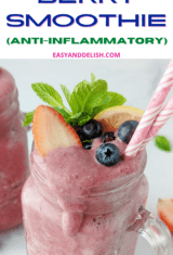 pin of anti-inflammatory berry smoothie garnished with mint, lemon,a nd mixed berries.