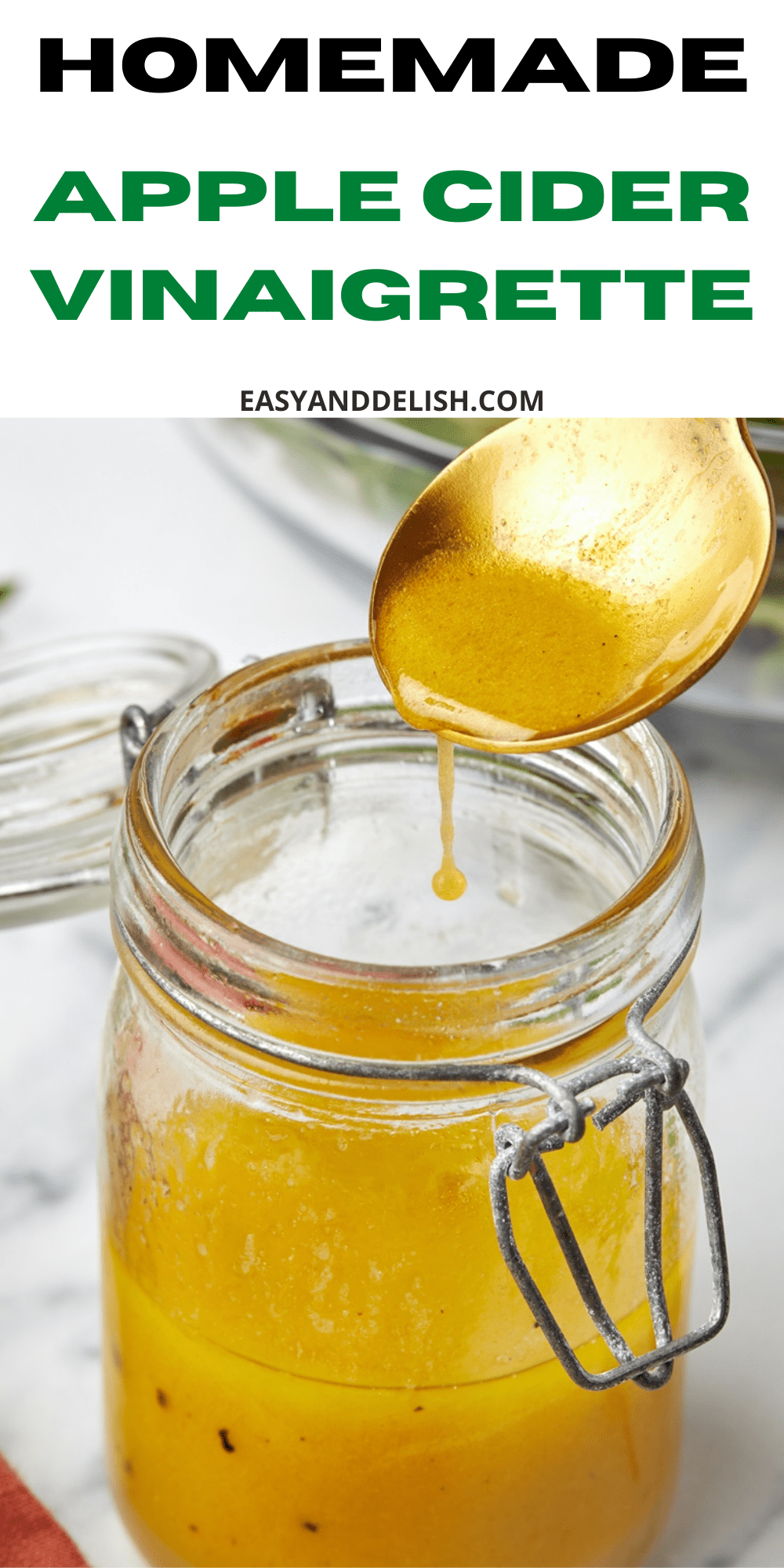 close up of a poon and jar of apple cider vinaigrette.