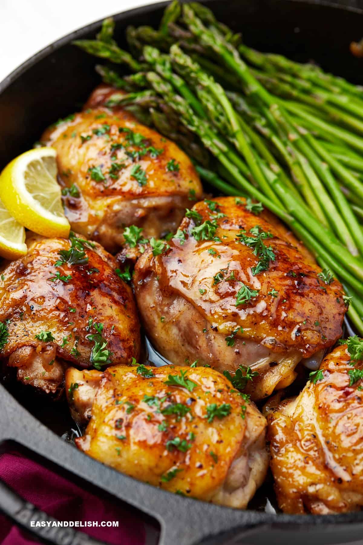 honey butter chicken with asparagus in a skillet.