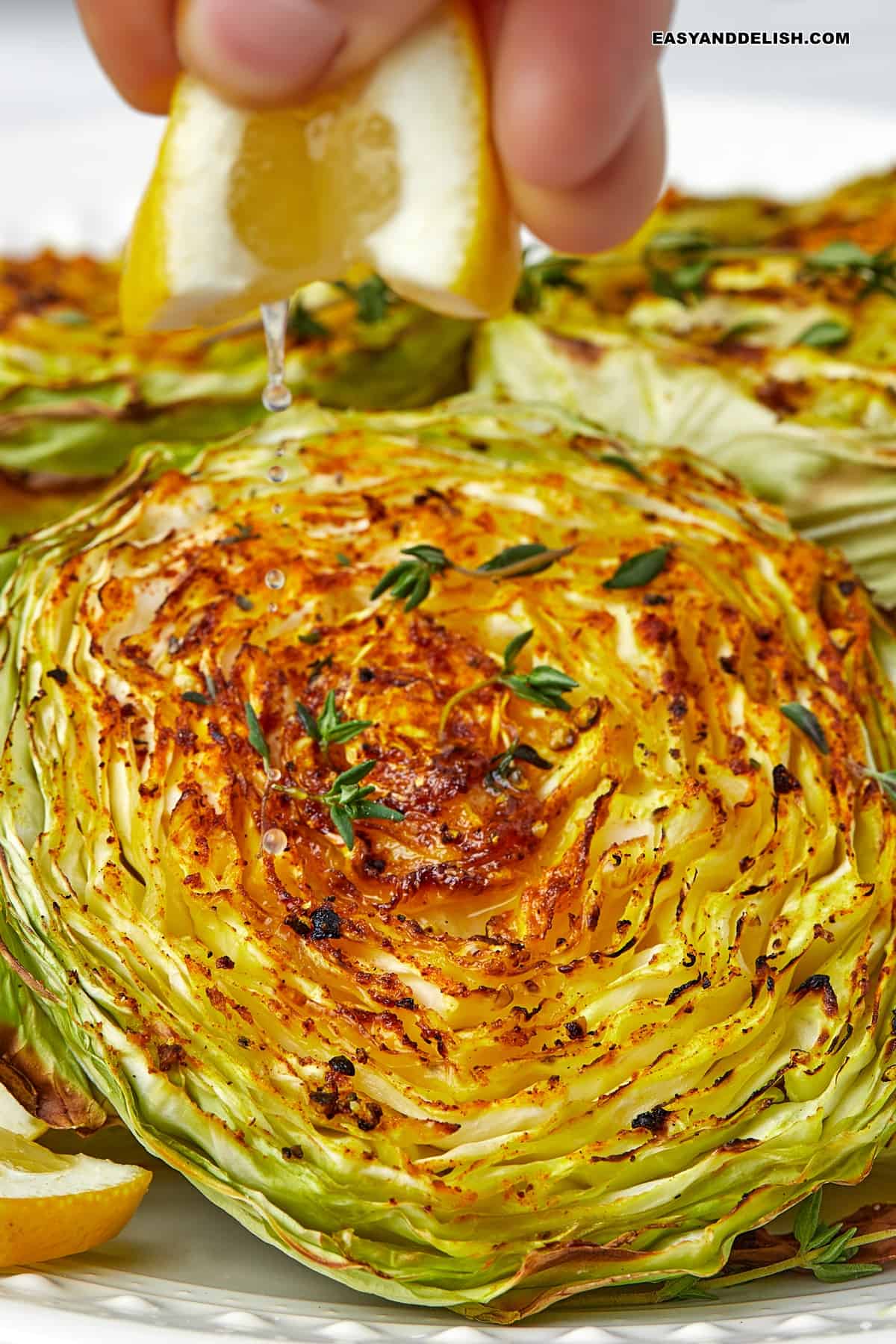 a lemon wedged squeezed over a grilled cabbage steak.