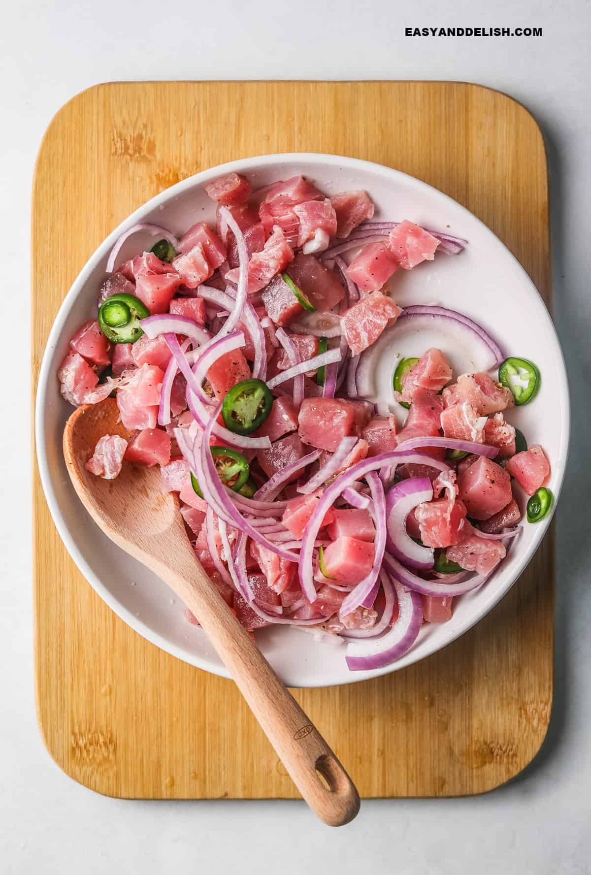 a bowl with the marinated fish with onions and jalapenos.